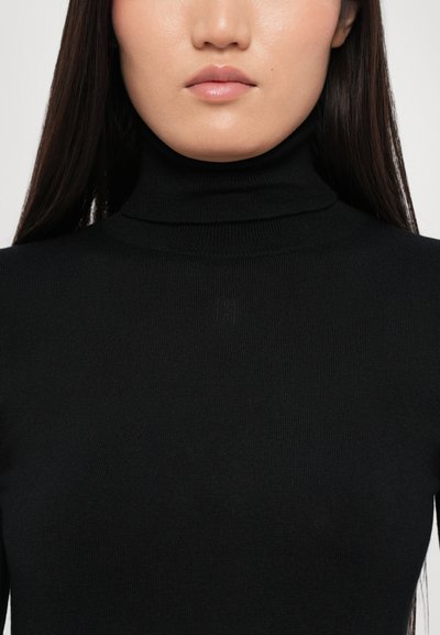 Mustmustiku turtleneck-kampsun, mis on valmistatud ribakujulisest materjalist. Omab lähedalt istuvat disaini, sujuvat tekstuuri ja diskreetset brändingut kaela lähedal.
