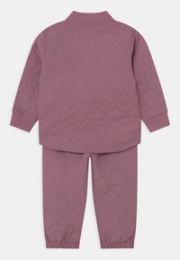 Quiltad tvådelad outfit i mauve, bestående av en bomberjacka med hög krage och elastiska manschetter, samt matchande byxor med elastiska anklar.