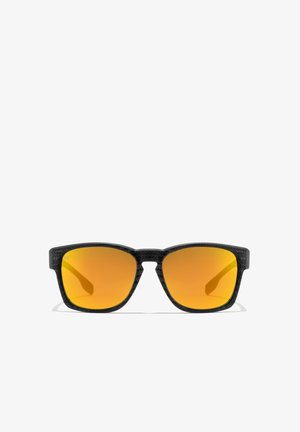 Mustad päikeseprillid tekstureeritud raami, ruudukujulise, kollaste paistjatega läätsede ja sirgete sangadega. Silmapaistev disain koos stiilse ja kaasaegse esteetikaga.