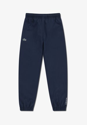 Navy blue track pants featuring a drawstring waist, elastic cuffs, and a Lacoste logo on the left thigh for a branded accent.
