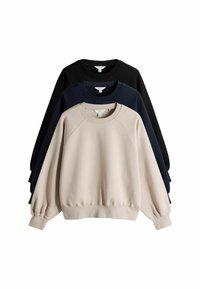 Drie stapelbare sweatshirts: één beige, één marineblauw, één zwart. Allemaal voorzien van ribgebreide manchetten en halslijnen, met een ontspannen pasvorm en een zachte textuur.