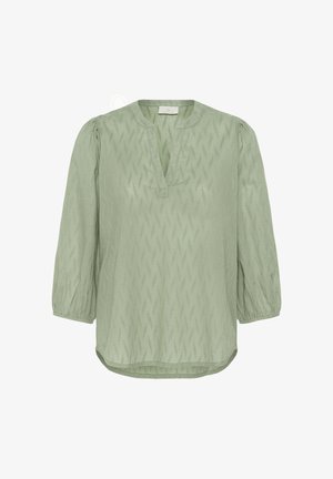 Lichtgroene blouse met structuur, driekwart pofmouwen, ronde hals met V-split en licht gebogen zoom.