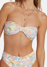 Kwiatowy bikini bandeau w pastelowej palecie kolorów. Teksturowany materiał z falbaniastymi detalami oraz wysokim stanem, z majtkami w pasującym wzorze.
