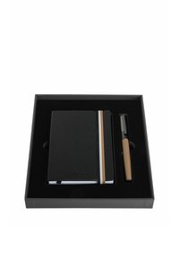 Carnet noir avec bande élastique rayée et stylo assorti dans une boîte de présentation noire.