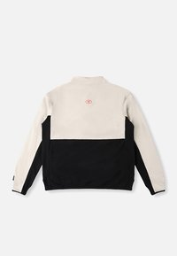 Giacca nera e beige con colletto alla coreana, caratterizzata da una texture liscia, design a blocchi di colore e un piccolo logo rosso sulla schiena.