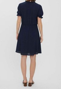 Marinblå skjortklänning med korta puffärmar och elastisk midja. Lätt tyg med en utsvängd kjol som slutar precis ovanför knäna.