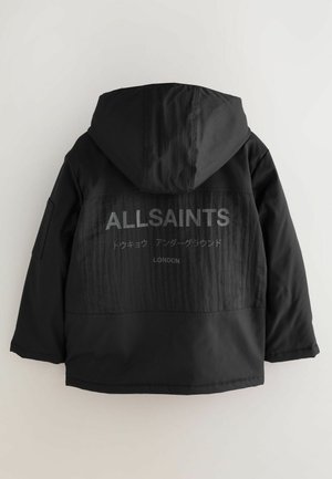 Musta huppari, jossa on teksturoitu takapaneeli ja "ALLSAINTS"-brändilogo sekä muuta tekstiä harmaana. Edessä on sileä pinta.