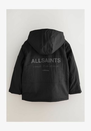 Melnā kapuce jaka ar faktūru aizmugurē, kurā redzams zīmola "ALLSAINTS" logo un cits teksts pelēkā krāsā. Priekšpuse ir gluda.