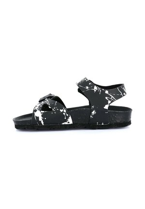 Sandali neri con un motivo a macchie bianche. Design open-toe, cinturino regolabile e suola testurizzata. Realizzati in materiale resistente.
