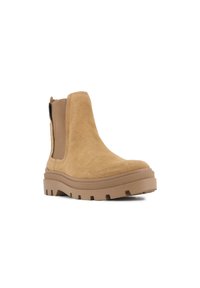 Botine Chelsea din suede bej, cu panouri elastice laterale, talpă groasă din cauciuc și un design cu vârf rotunjit. Suprafață texturată și talpă profilată.
