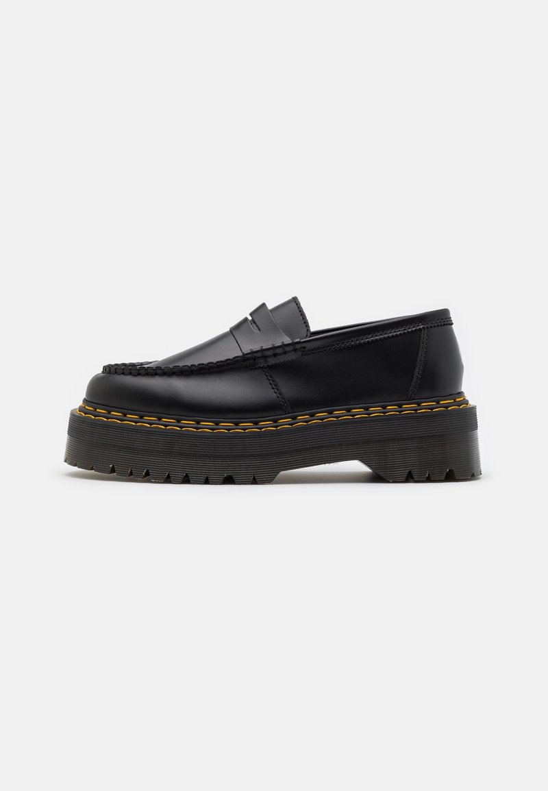 Mocassin à plateforme en cuir noir avec semelle épaisse crantée et couture jaune le long du bord de la semelle, présenté en profil latéral.