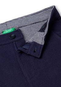 Polo de color azul marino con una tela texturizada, cuenta con un forro de cuello a rayas, cierre frontal de botones y un detalle de bolsillo interior.