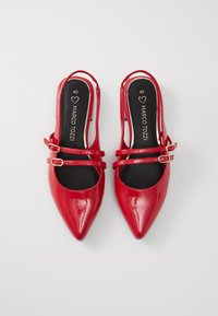 Décolleté slingback in pelle verniciata rossa, con punta appuntita, caratterizzate da due sottili cinturini con fibbia e una soletta nera con branding dorato. Taglia 40.