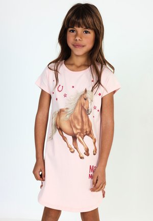 Young girl with long brown hair wearing a light pink dress featuring a running horse and red stars on a white background.