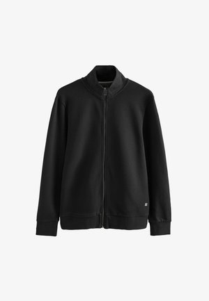 Musta vetoketjullinen takki, jossa on teksturoitu, hengittävä yläosa. Ominaisuuksiin kuuluu korkea kaulus, pitkät hihat ja yhtenäinen alaosa.