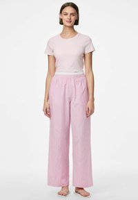 Kerge roosa sobiv T-särk, millele on sobitatud triibulised laiad roosad püksid, millel on valged ja lillad triibud, elastne vöökoht ja lihtsad sandaalid.