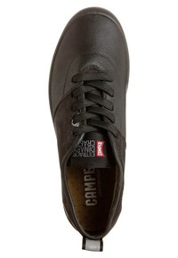 Baskets en cuir noir avec des lacets noirs, étiquette rouge Camper sur la languette et "Camper Lightweight" visible sur la semelle intérieure.