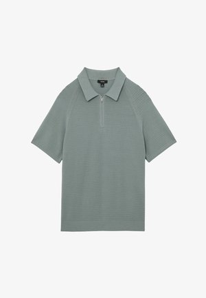 Koszulka polo z krótkim rękawem wykonana z miękkiej, teksturowanej tkaniny w jasnej zieleni, z kołnierzem na suwak i ściągaczem u dołu. Minimalistyczny design i nowoczesny krój.