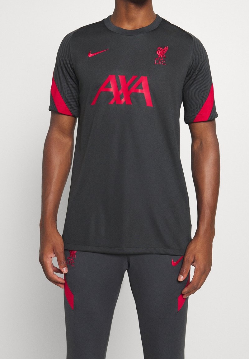 Szary węglowy sportowy jersey Nike z czerwonym logo "AXA" oraz emblematem Liverpool F.C. Posiada czerwone akcentowane rękawy i teksturowany wzór na ramionach.