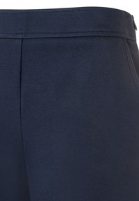 Marineblauer Stoff mit glatter Textur, ausgestattet mit einem maßgeschneiderten Bund und Falten auf einer Seite für einen strukturierten Look.