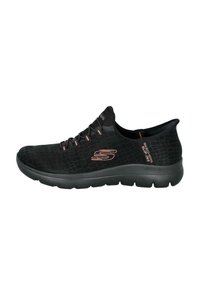 Zapatillas de tela negras con un patrón texturizado, suela de goma y sutiles acentos en rosa. Con cordones elásticos y un diseño acolchado.