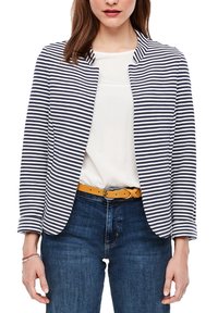 Veste rayée marine et blanche avec encolure ronde, devant ouvert et manches longues, associée à un haut blanc et un jean bleu.