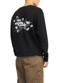 Sudadera negra de manga larga con un gráfico floral y el logo "JACK & JONES" impreso en blanco en la parte posterior. Material de algodón, corte relajado.