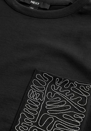 Zwarte T-shirt met een gestructureerde zak en een zilveren, kronkelige lijnontwerp. Gemaakt van katoen, heeft het een ronde hals en korte mouwen.