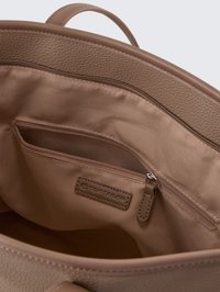 Innenraum einer braunen Lederhandtasche mit glatter Oberfläche, ausgestattet mit einer Reißverschlusstasche, einer Markenetikette und einem weichen Textilfutter.