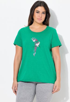 T-shirt vert à manches courtes avec un col rond, comportant un motif floral coloré sur le devant. Tissu doux, coupe décontractée et sans coutures visibles.