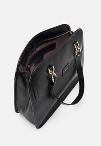 Sac à main en cuir noir avec un design structuré, fermeture éclair, éléments métalliques dorés et doublure intérieure à motif.