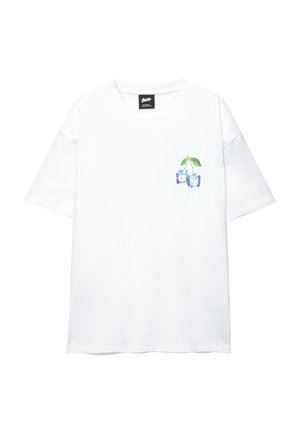 Fehér pamut póló, bal mellen egy világoskék grafikával, amelyen két cseresznye zöld levelekkel látható. Rövid ujjú és laza szabású.