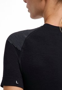 Czarna sportowa koszulka z okrągłym dekoltem, krótkimi rękawami i paskami na ramionach, wykonana z teksturowanego, oddychającego materiału.