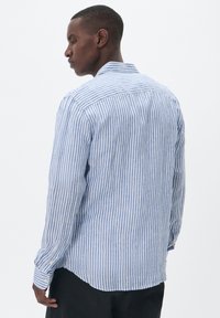 Camicia a maniche lunghe verticalmente a righe blu e bianche, realizzata in tessuto leggero, con colletto classico e polsini abbottonati.