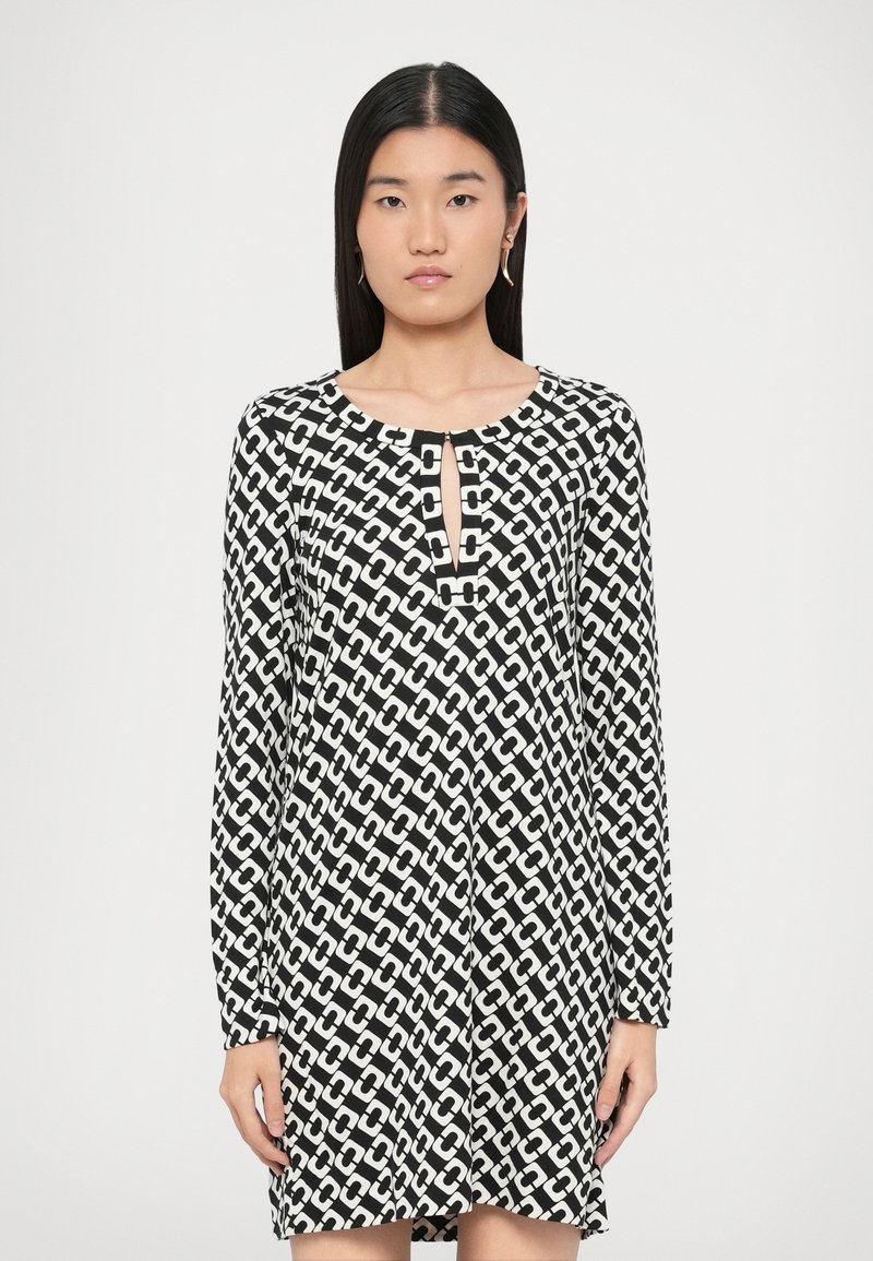 Melna un balta garroku kleita ar ģeometrisku ķēžu rakstu, apaļu izgriezumu ar atslēgas cauruma detaļu un brīvu piegulumu.