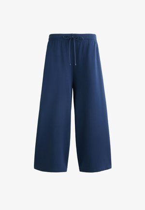 Mörkblå vida byxor tillverkade av ett mjukt material, med resårmidja och dragsko samt utan synliga fickor eller mönster.