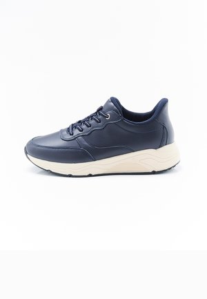 Marineblauwe leren sneaker met witte dikke zool en zwarte veters, zijaanzicht op een witte achtergrond.
