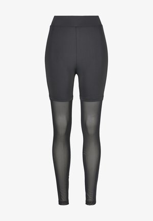 Shorts actifs noirs avec une taille haute, présentant une partie supérieure lisse et une partie inférieure en maille transparente, conçus pour le confort et la respirabilité.
