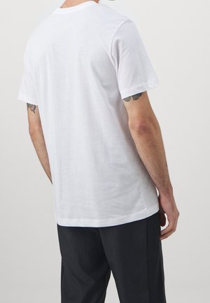 Vit bomulls t-shirt med korta ärmar och rundad halsringning, med en avslappnad passform och en jämn, enfärgad yta.