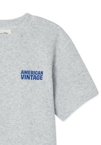 Hellgraues Baumwoll-T-Shirt mit Rundhalsausschnitt und kurzen Ärmeln; vorne auf der Brust blaue Stickschrift "AMERICAN VINTAGE".