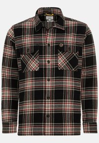 Camisa de franela negra con un patrón de cuadros en rojo y blanco, con dos bolsillos en el pecho y cierre de botones, fabricada en tejido de peso medio.