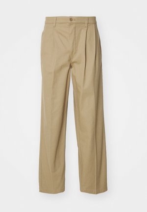 Beige široke hlače iz mešanice bombaža. Imajo sprednje gube, zapiranje na gumb in žepe za funkcionalnost. Gladka tekstura.