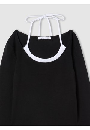 Top nero a maniche lunghe con scollatura a girocollo, bretelle bianche regolabili e design a strati. Tessuto morbido con una trama liscia.