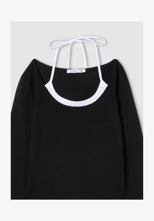 Top nero a maniche lunghe con scollatura a girocollo, bretelle bianche regolabili e design a strati. Tessuto morbido con una trama liscia.