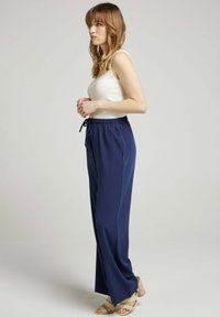 Pantalons bleu marine, longueur cheville en tissu léger, avec une taille élastique dotée d'un cordon de serrage et des poches latérales.