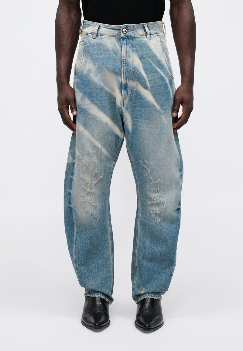 Ljusblå denimjeans med lös passform, med slitna detaljer och vita tie-dye-mönster över hela. Femficksdesign med bälteshällor.