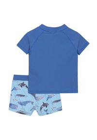 Tvådelad badset bestående av en enfärgad blå t-shirt med korta ärmar och ljusblå shorts med olika valmönster. Tillverkat av elastiskt tyg.