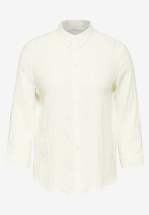 Bílá texturovaná košile s dlouhými rukávy a límečkem. Má volný střih a jemný vertikální pruhovaný vzor.