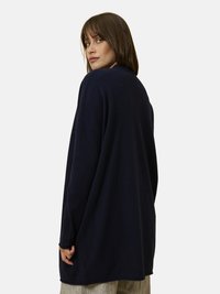 Marinblå oversized långärmad tröja med en mjuk textur, rundad halsringning, sänkta axlar och sidofickor för enkel rörelse.