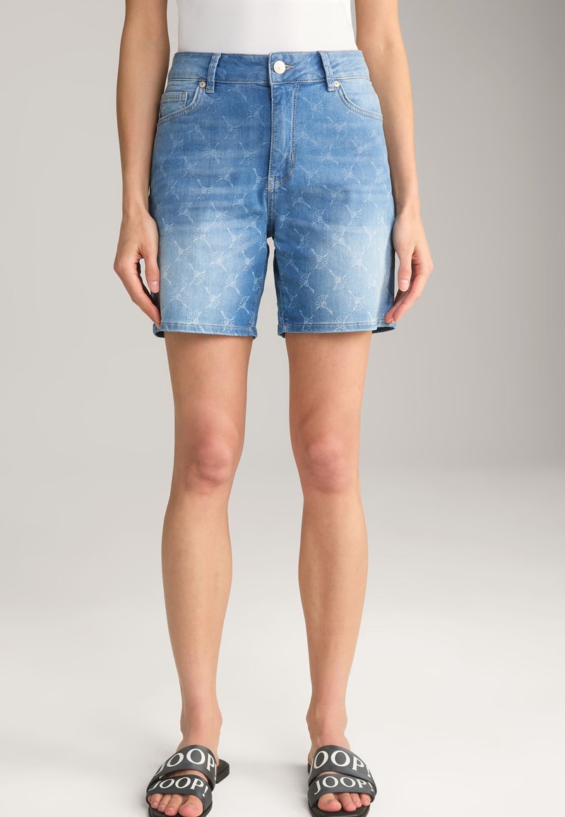 Jeansshorts i ljusblått med blekt struktur och subtilt blommönster, med knappstängning och uppvikta fållar.